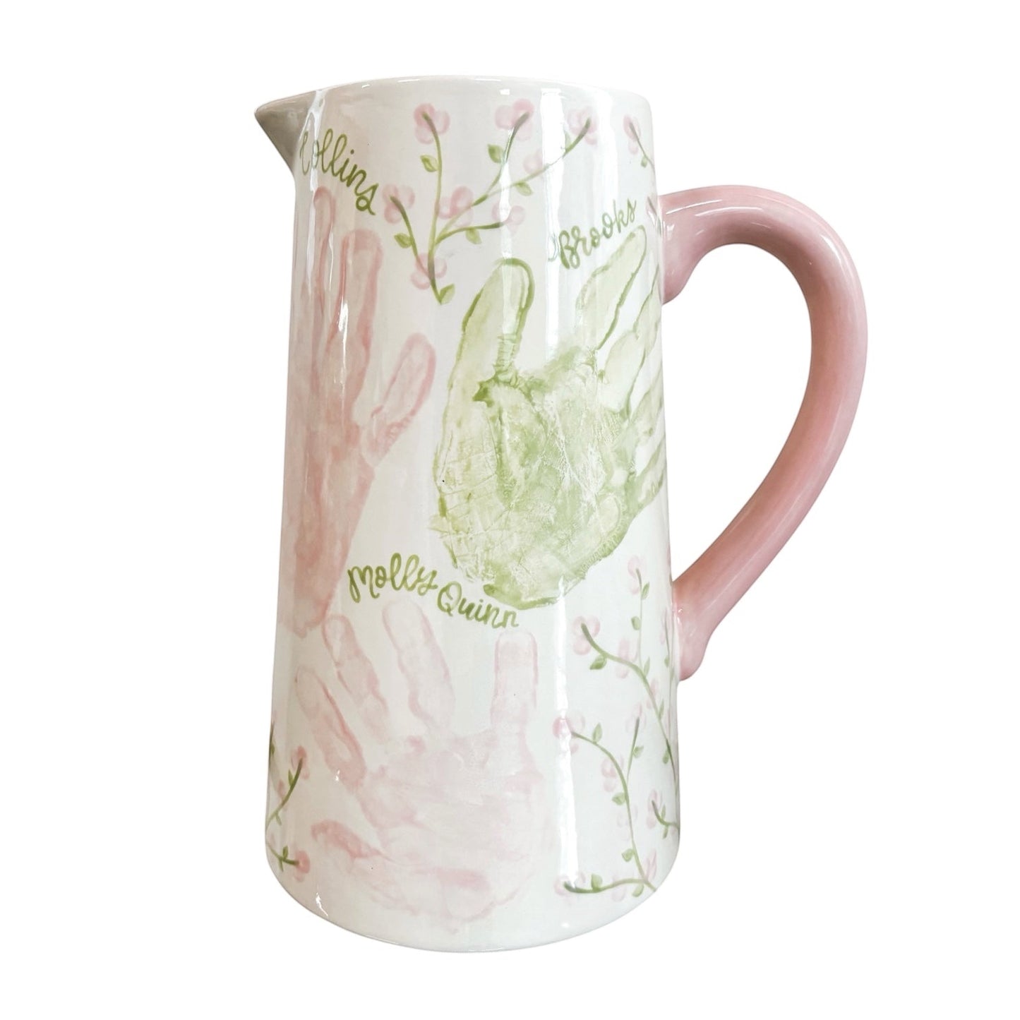 Weeks Studio hand-painted white ceramic pitcher with pastel handprints, floral vines, and a solid pink handle.
