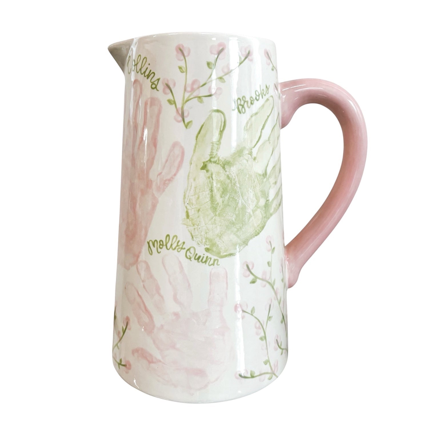 Weeks Studio hand-painted white ceramic pitcher with pastel handprints, floral vines, and a solid pink handle.