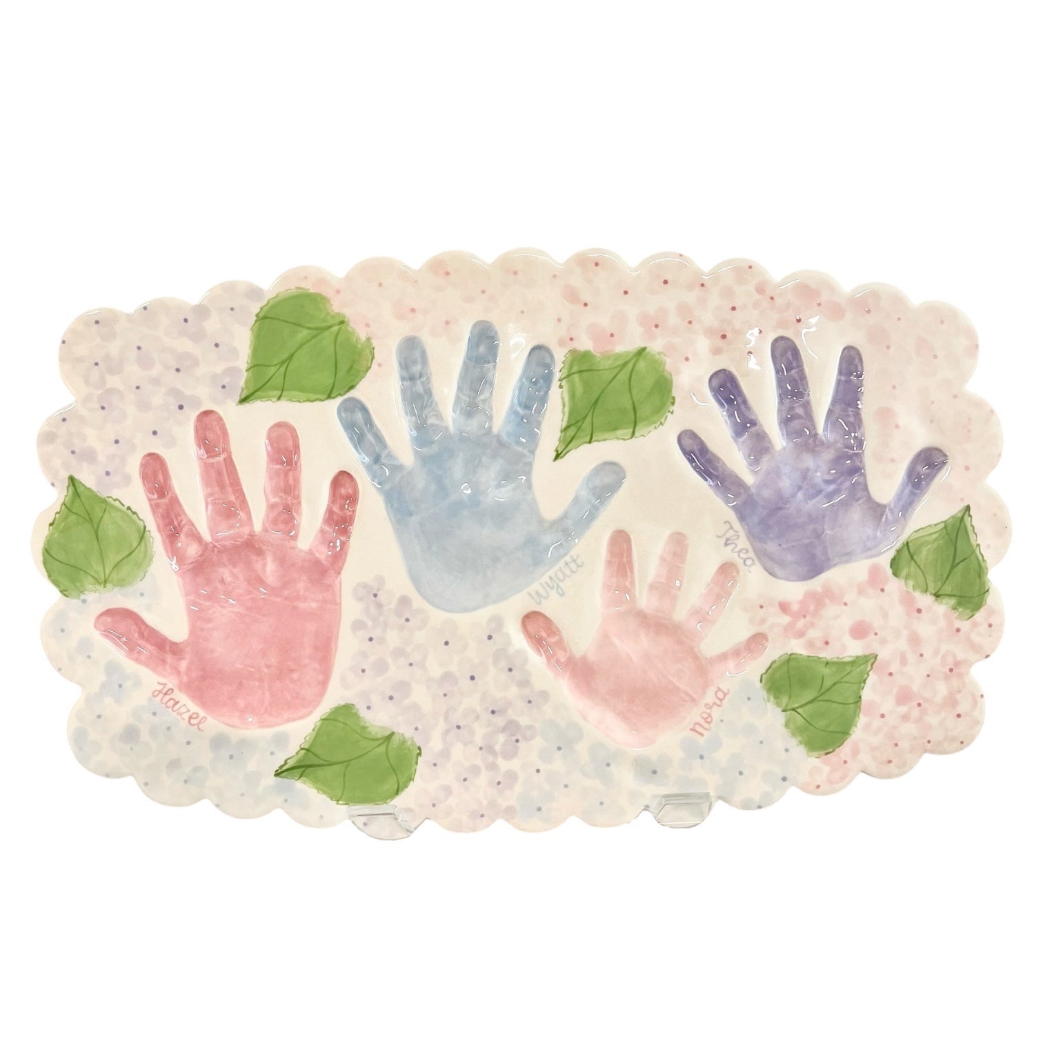 Weeks Studio ceramic keepsake platter with scalloped edges, featuring four colorful handprints and painted green leaves.