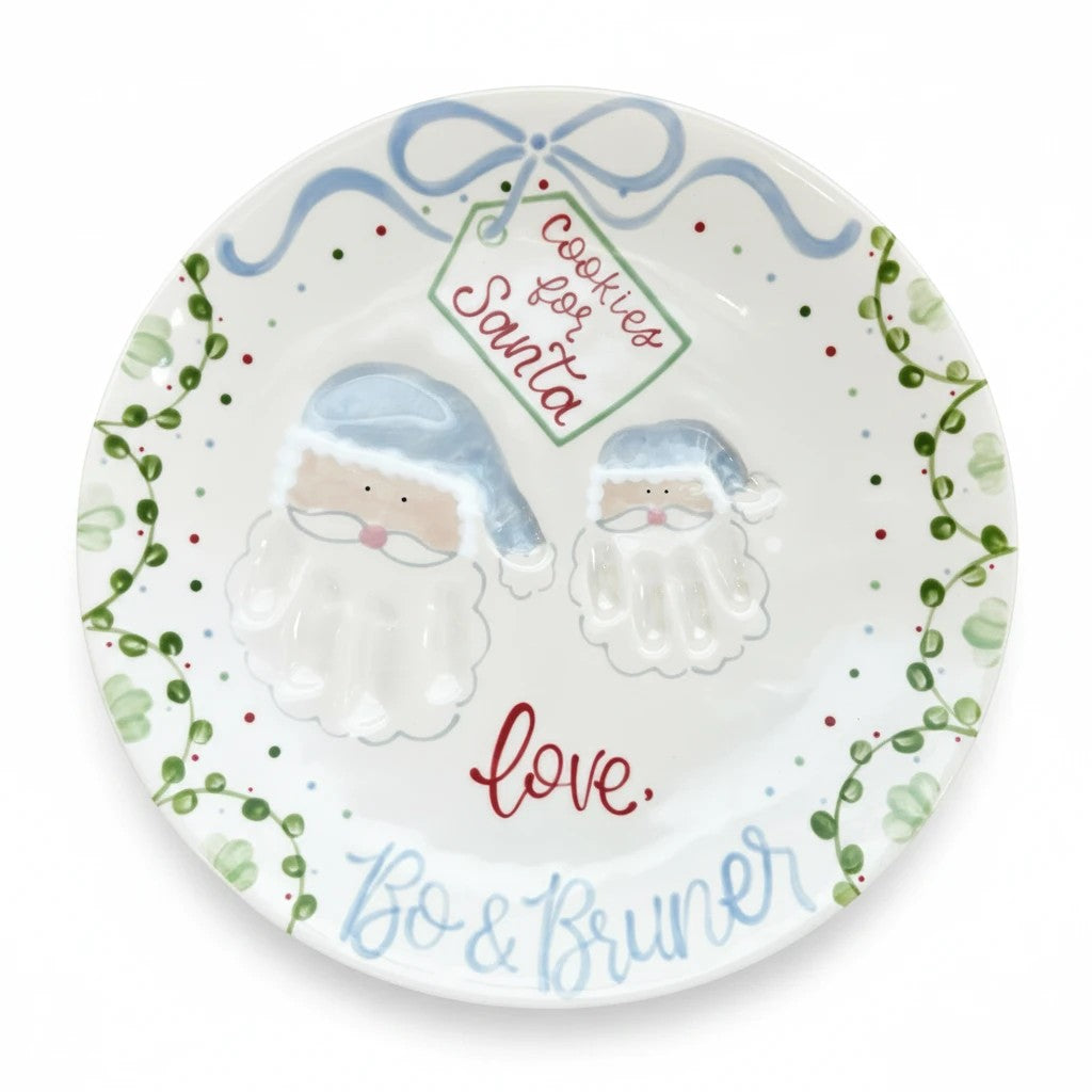 Weeks Studio ceramic Santa plate featuring hand-painted blue Santa hats, festive greenery, and personalized names.