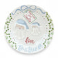Weeks Studio ceramic Santa plate featuring hand-painted blue Santa hats, festive greenery, and personalized names.
